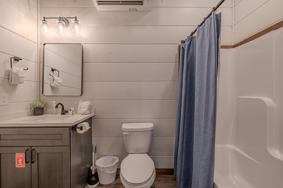Full bathroom in lower level nearest the pool room also offers a bathtub.