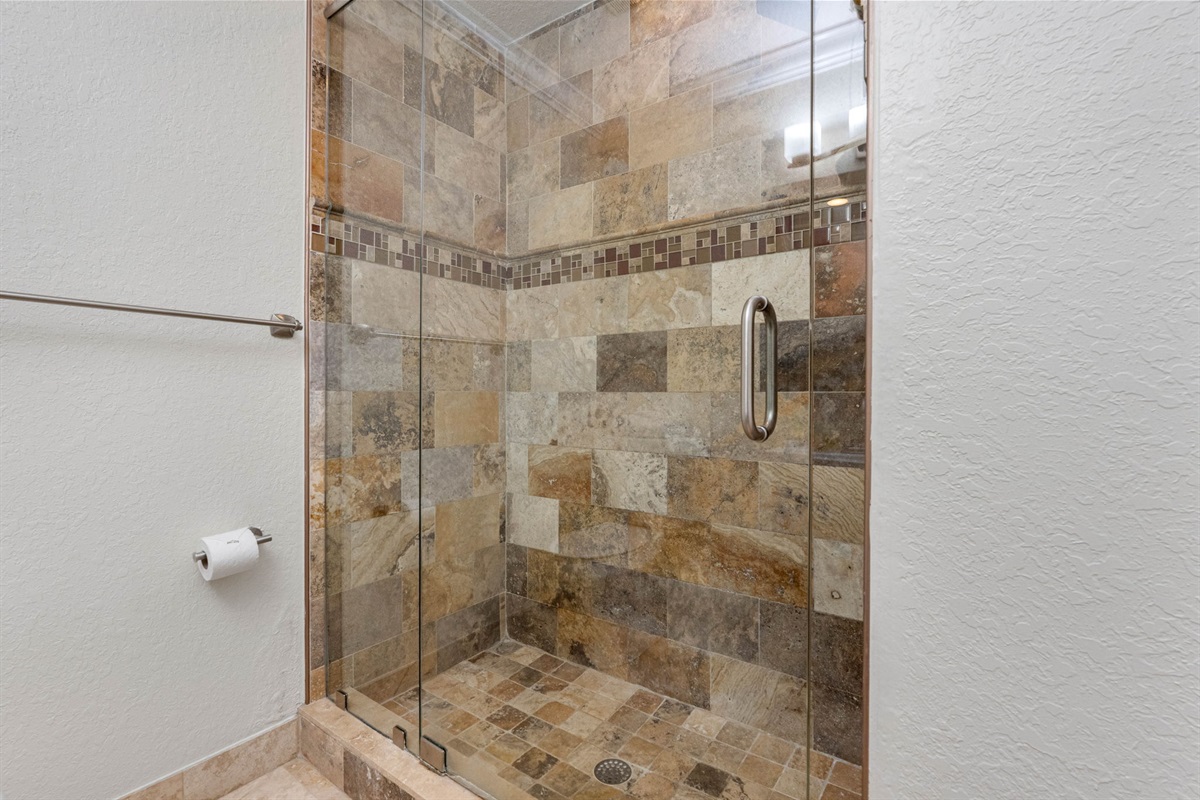 A walk-in shower with glass enclosure offers a refreshing alternative, ideal for a quick rinse or rejuvenating morning routine.