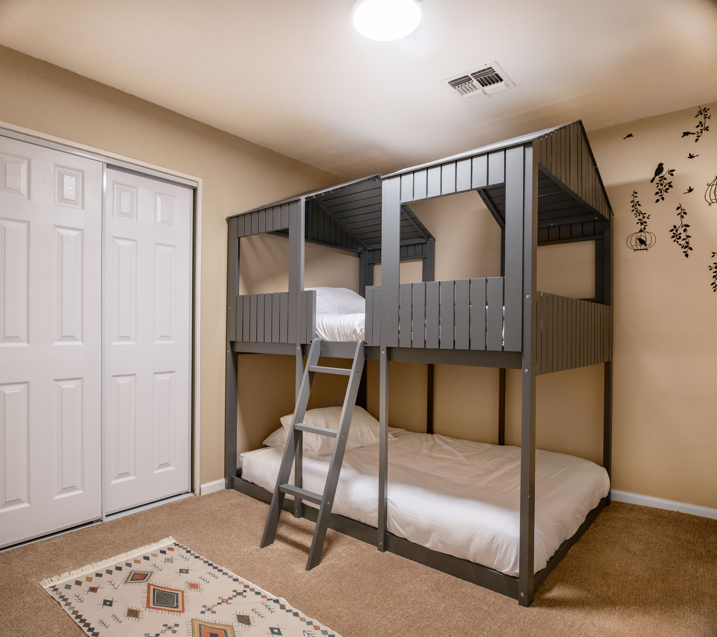 Designed with little adventurers in mind, this fun bunk room features a custom cabin-style frame and cozy bedding for the perfect sleepover vibe.