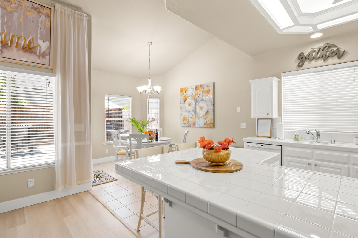 The bright and airy kitchen flows seamlessly into the dining area, creating the perfect space for sharing meals, conversations, and quality time together.