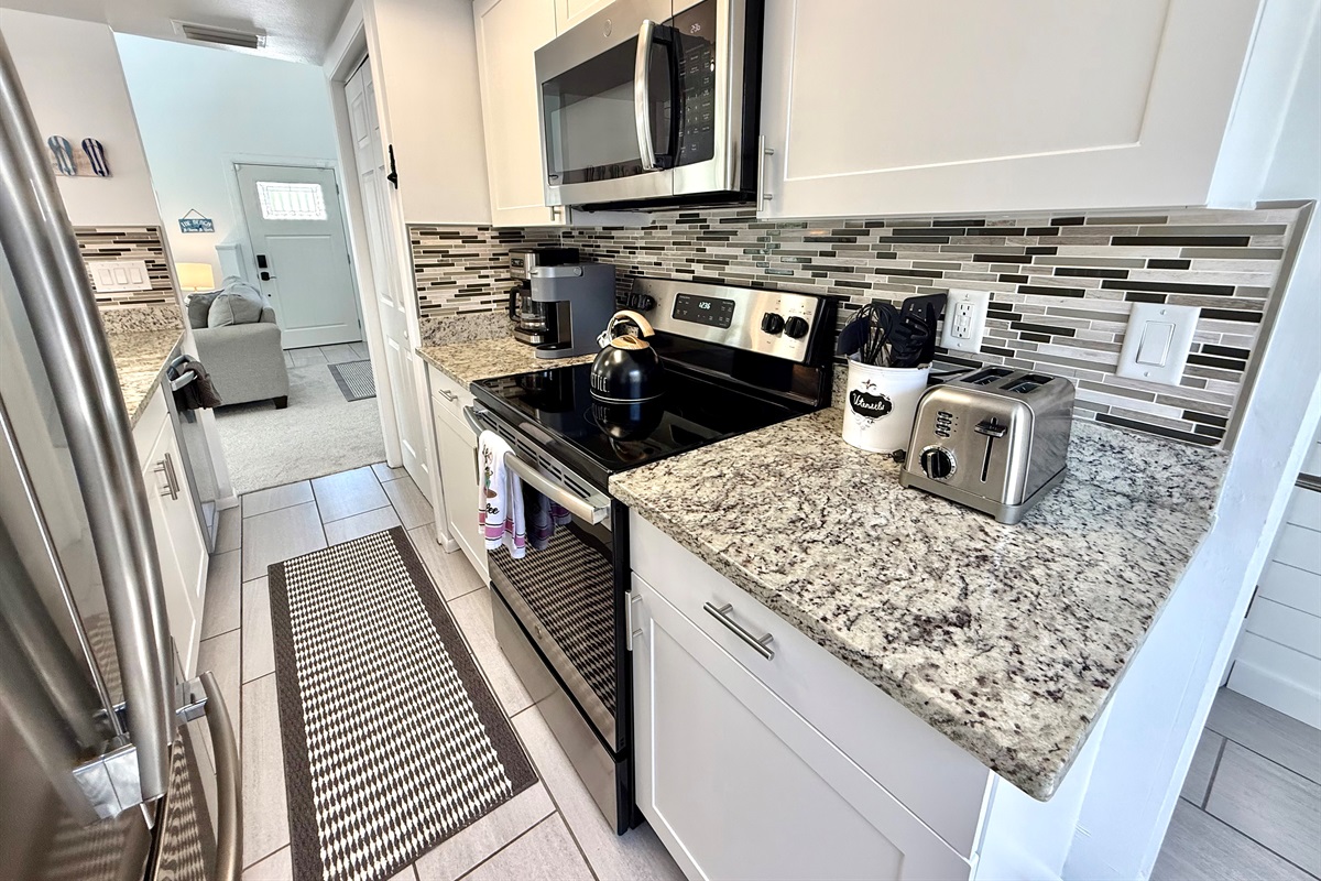 This fully equipped kitchen features stainless steel appliances, granite countertops, and a stylish backsplash — perfect for whipping up family meals.