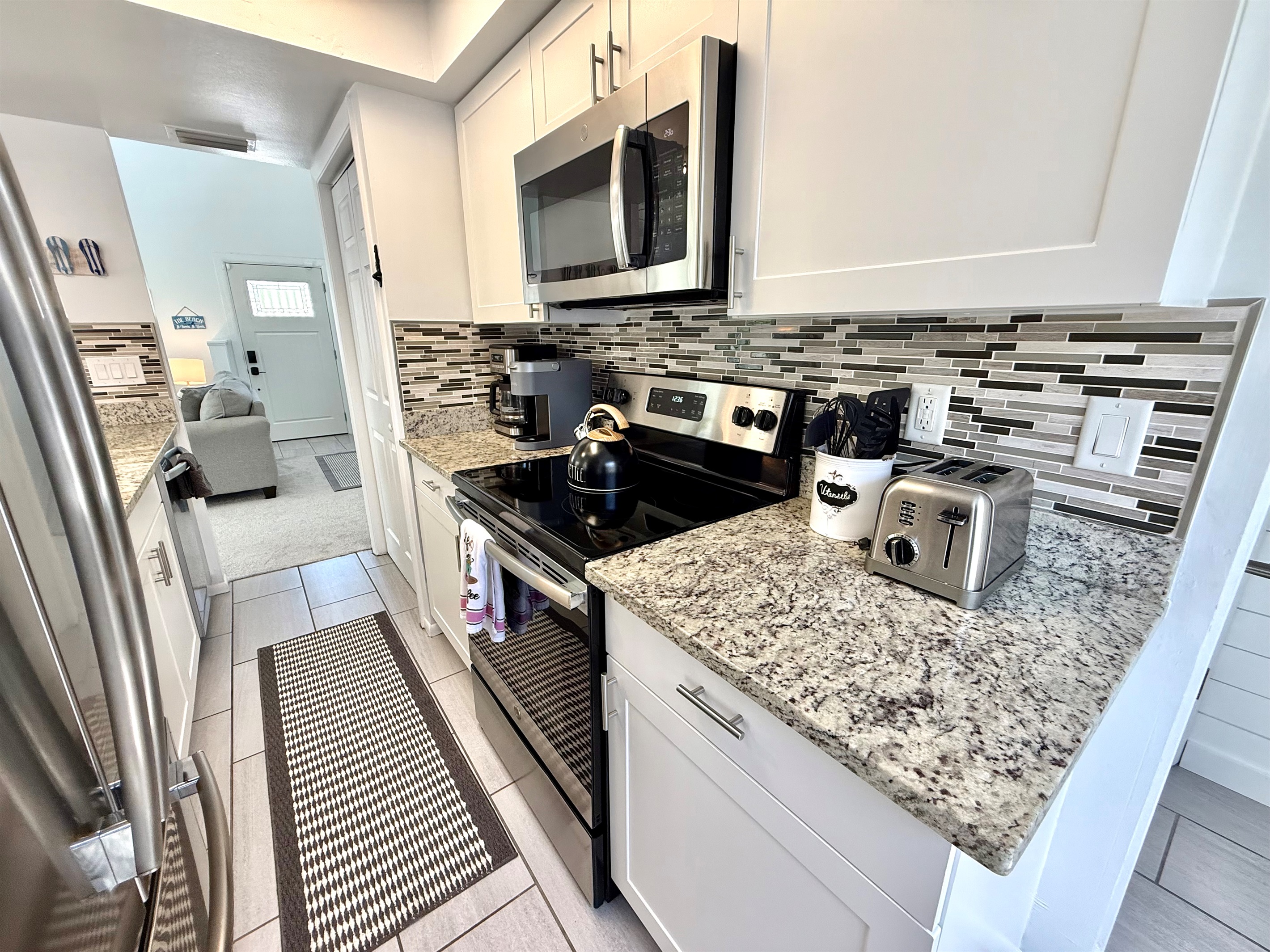 This fully equipped kitchen features stainless steel appliances, granite countertops, and a stylish backsplash — perfect for whipping up family meals.