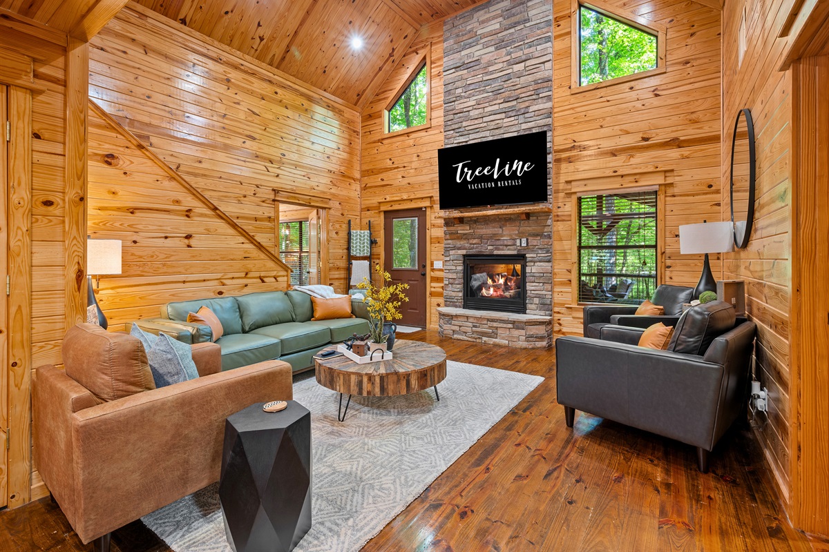 Warm and inviting living room with soaring ceilings, a modern fireplace, and comfy seating for movie nights or cozy gatherings.