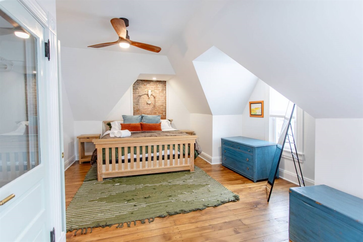 A spacious bedroom with a large window that fills the room with natural light, creating a bright and airy atmosphere perfect for relaxation.
