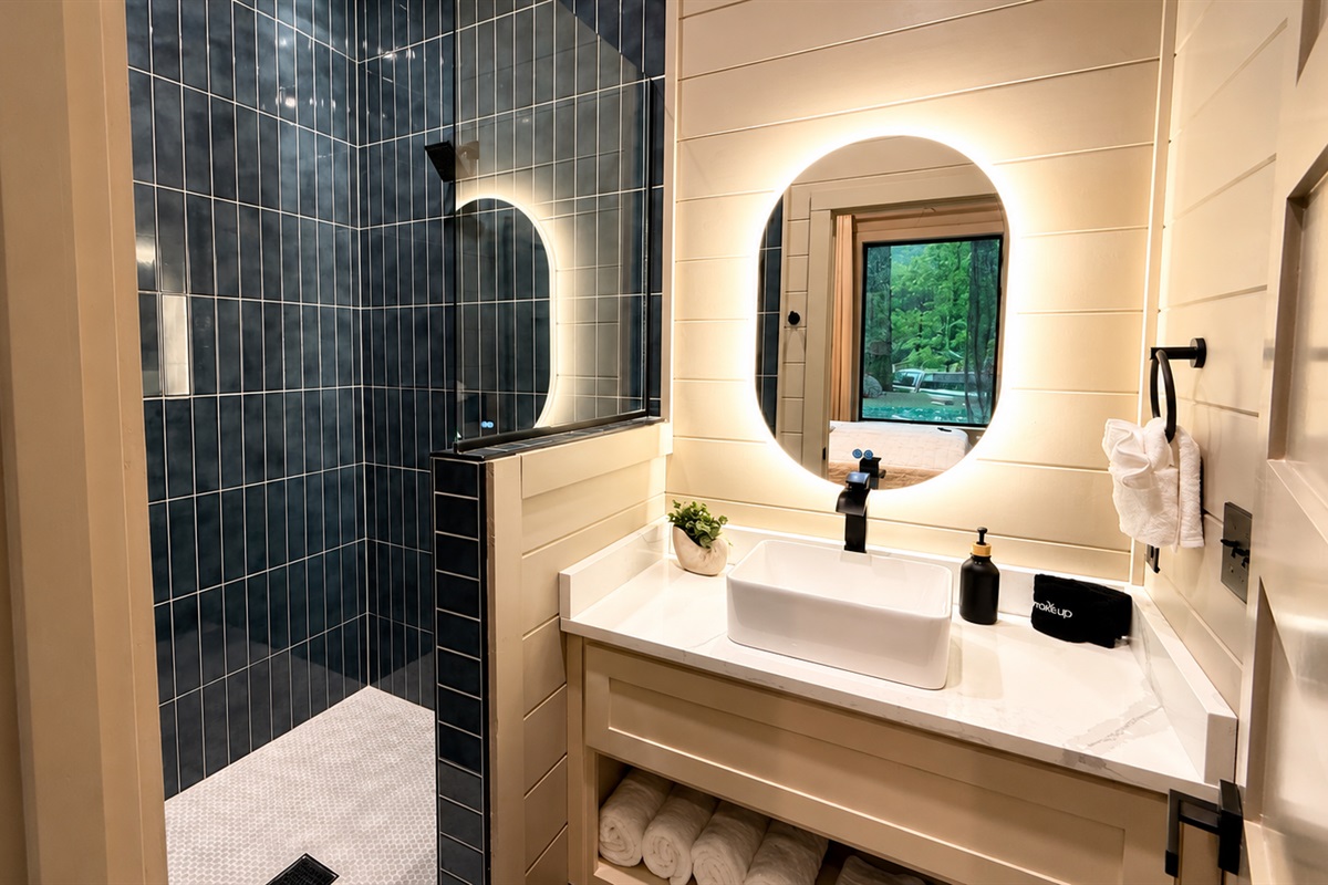 Luxurious Bathroom: Refresh in a stunning tiled retreat with nature views and elegant lighting!