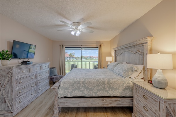 Master bedroom with ceiling fan, ensuite bathroom, smart TV and clothing storage