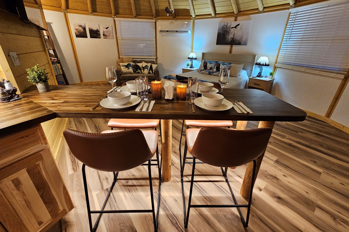 Enjoy meals together at the handcrafted dining bar overlooking the open-concept living and sleeping space at Eagle Retreat—thoughtfully designed for comfort, warmth, and connection