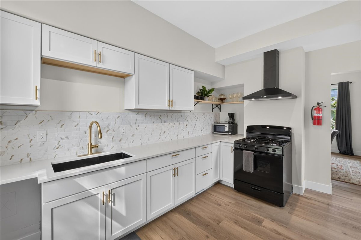 Fully equipped kitchen with an oven, stovetop, and cooking utensils.
