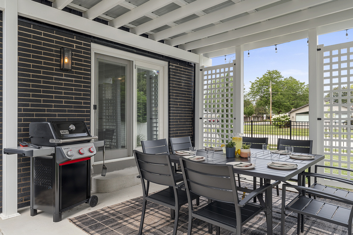 Covered outdoor dining for eight with a Weber gas grill.