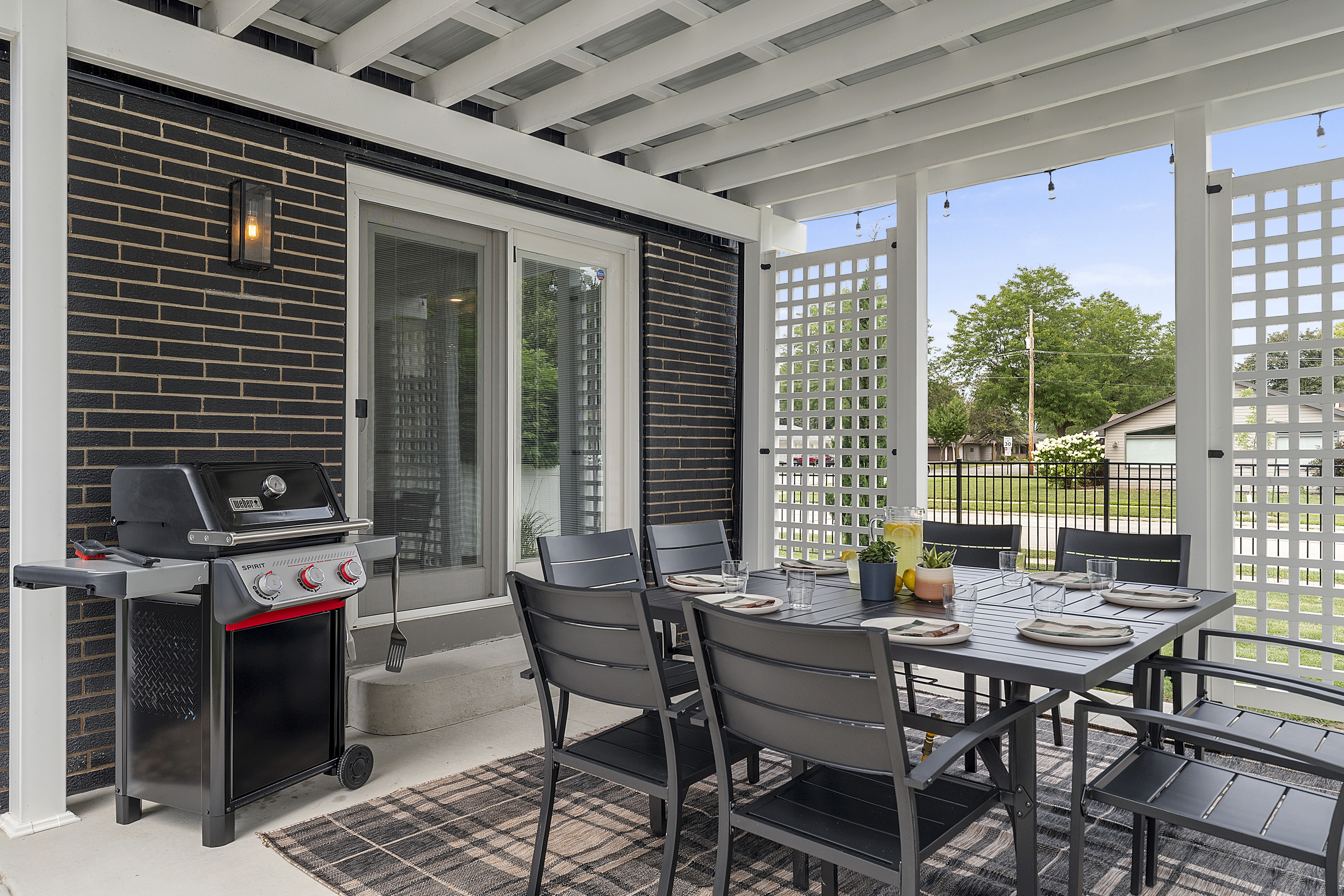 Covered outdoor dining for eight with a Weber gas grill.