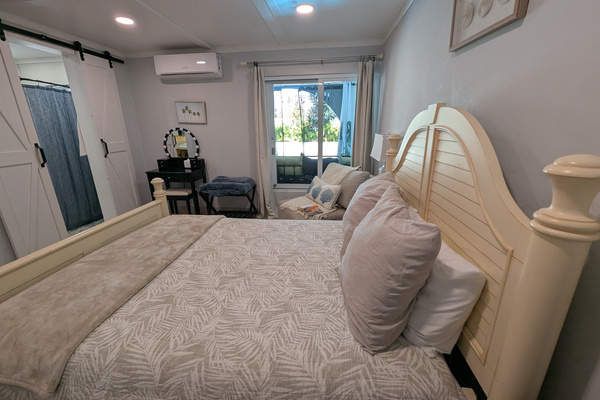 Bright queen bedroom at Villa Coral featuring an adjustable motorized bed base, vanity station, and lovely view to the pool in Dorado, Puerto Rico.
