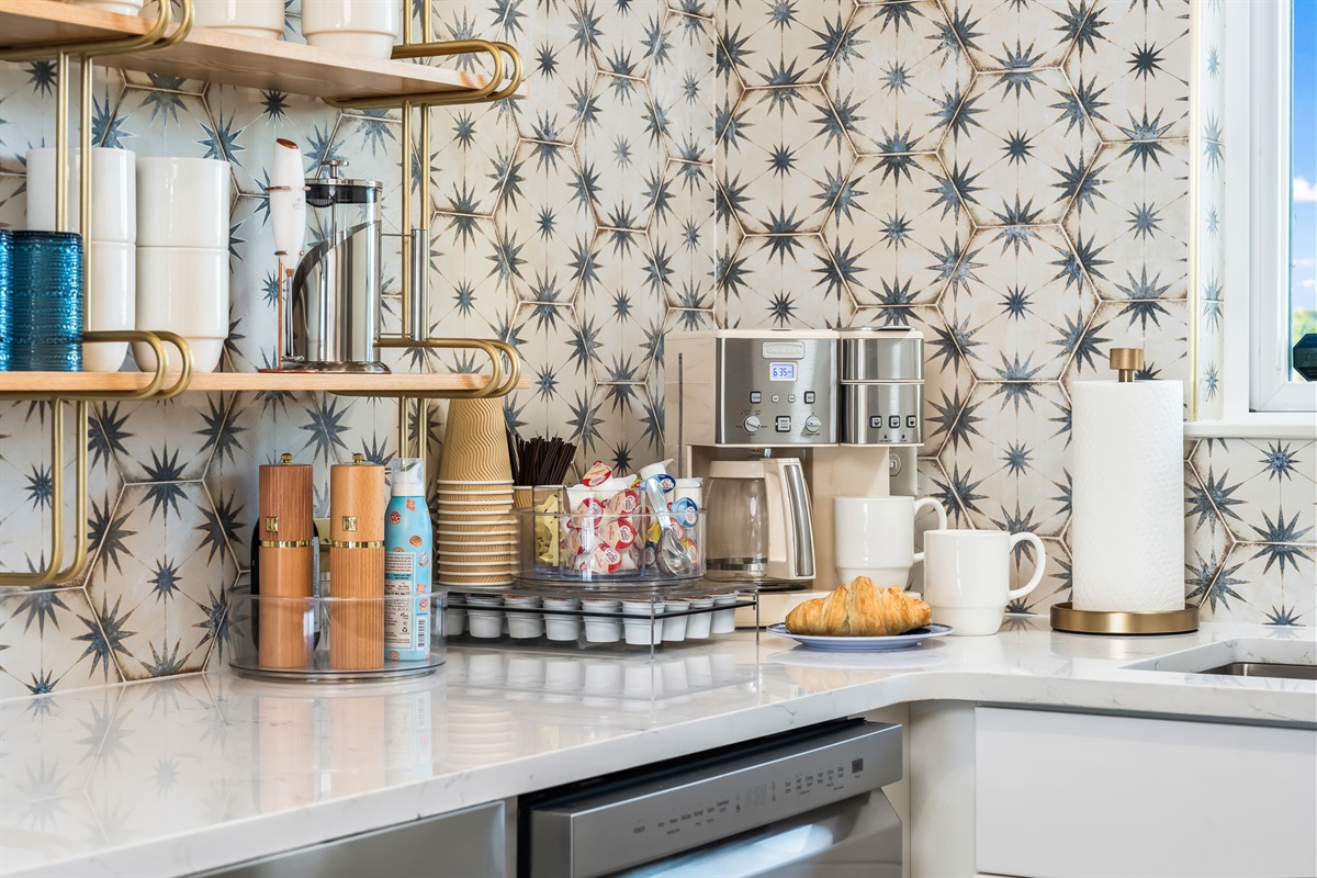 A well-stocked kitchen counter with coffee setup and storage.