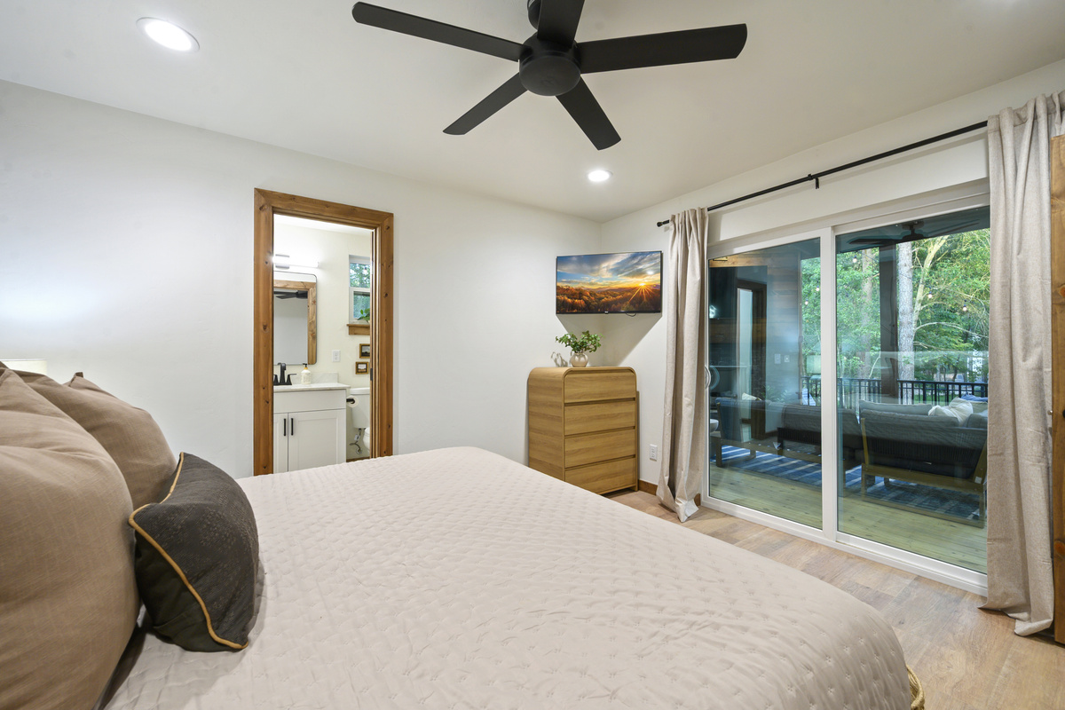 Wake up to the trees just outside your door. This king suite opens directly onto the covered deck, pairing a private ensuite with easy access to the outdoor living spaces.
