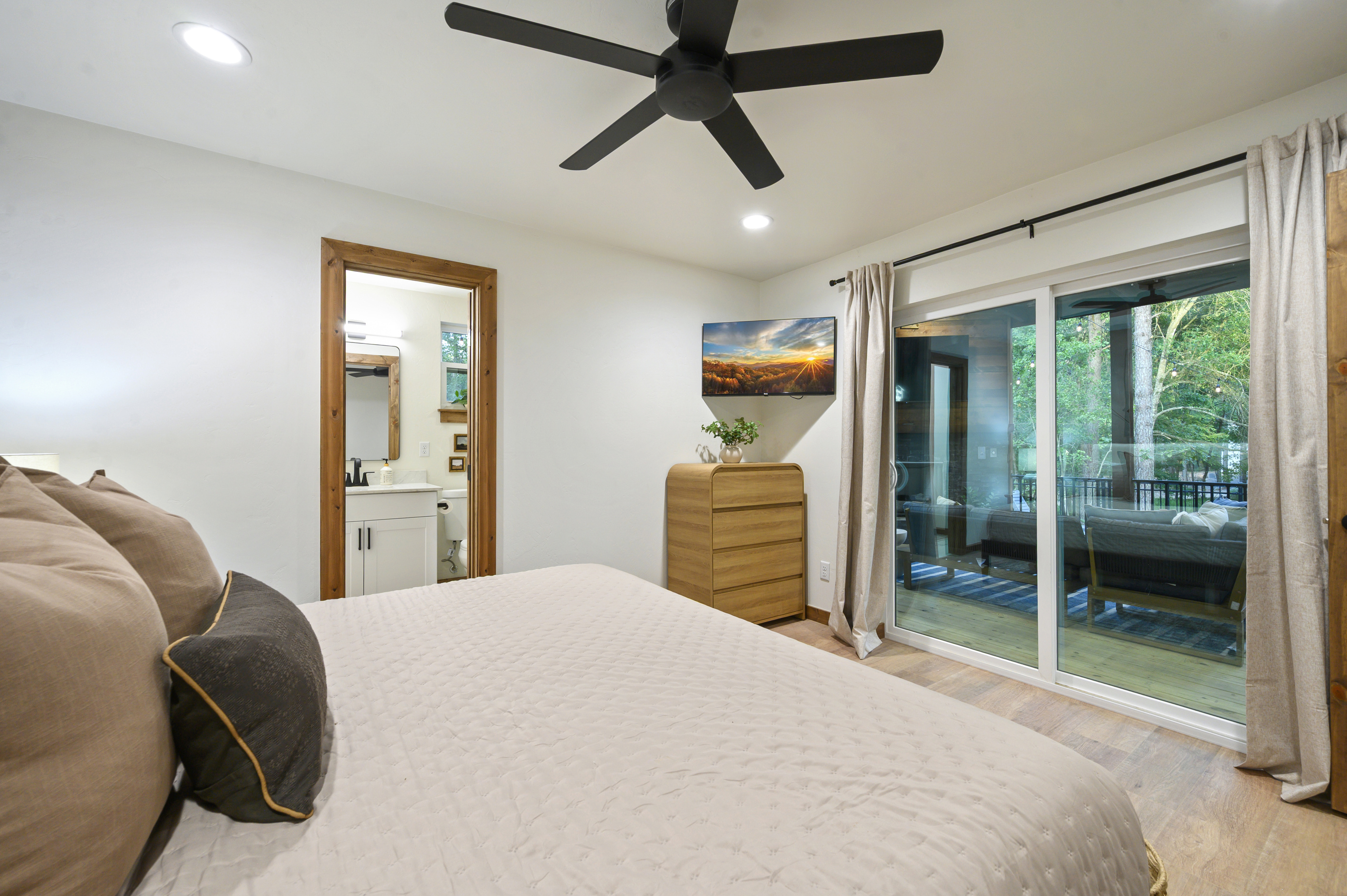 Wake up to the trees just outside your door. This king suite opens directly onto the covered deck, pairing a private ensuite with easy access to the outdoor living spaces.
