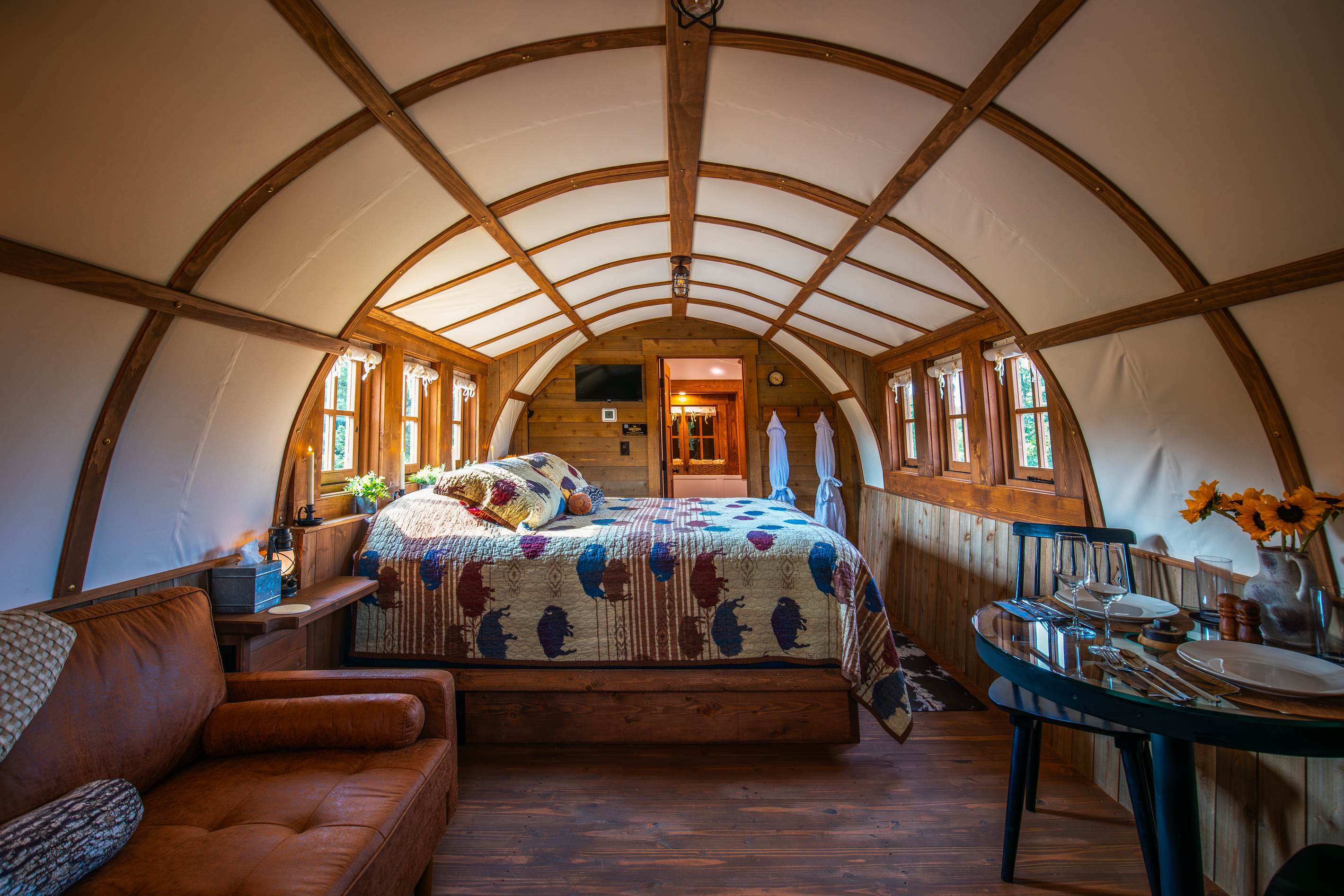 Step inside the cozy covered wagon with a king bed, sitting area, dining space, and private bath.