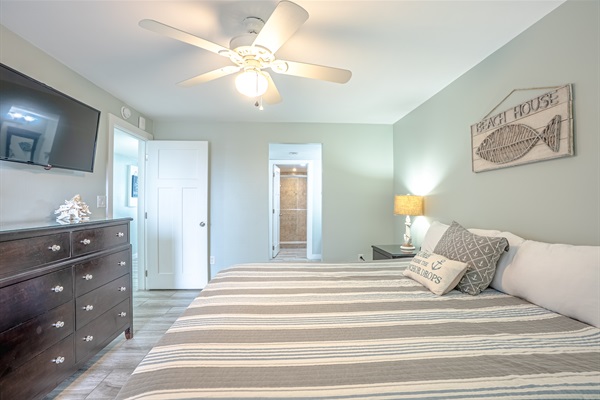 Master bedroom with king bed, ceiling fan, smart TV and ensuite bathroom