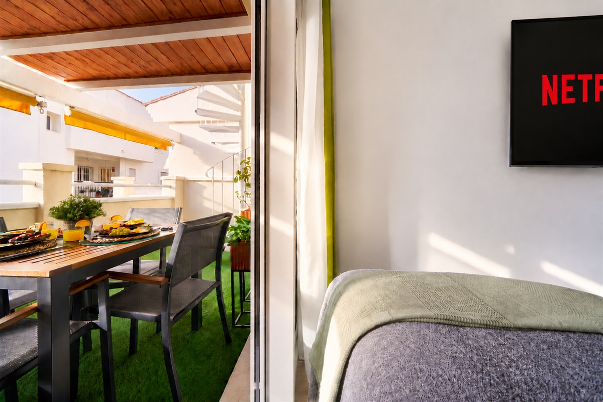 Bright and calming twin bedroom with tropical tones, soft linens, and direct access to the terrace - perfect for relaxed mornings and restful nights.