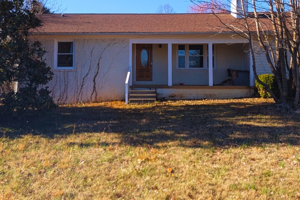 Welcoming home with a spacious front lawn and charming covered porch, a peaceful place to relax and unwind
