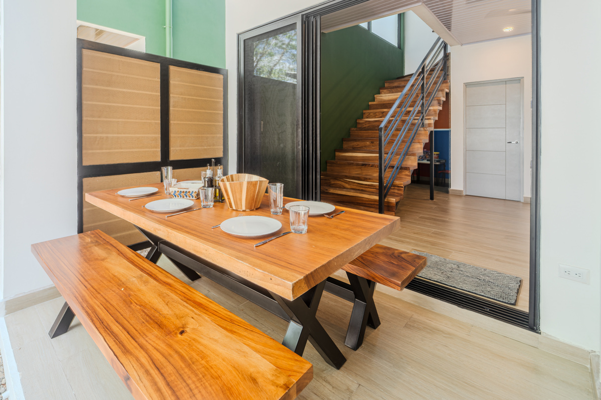 Outdoor dining under a covered roof that seats six. The dining area connects kitchen, terrace, and living room. The heart of the home