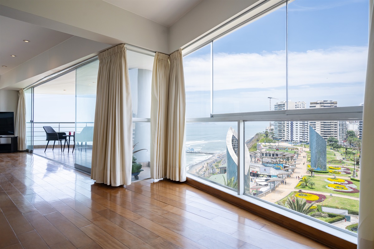 View from the living room to the Malecón and the Pacific Ocean — a postcard-perfect moment every day.  /   Vista desde la sala al Malecón y al Océano Pacífico: un momento de postal perfecto cada día.