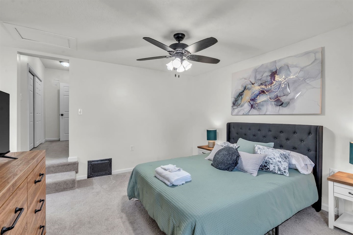 Spacious bed with a ceiling fan, offering ultimate comfort and a cool, relaxing atmosphere for a restful night's sleep.