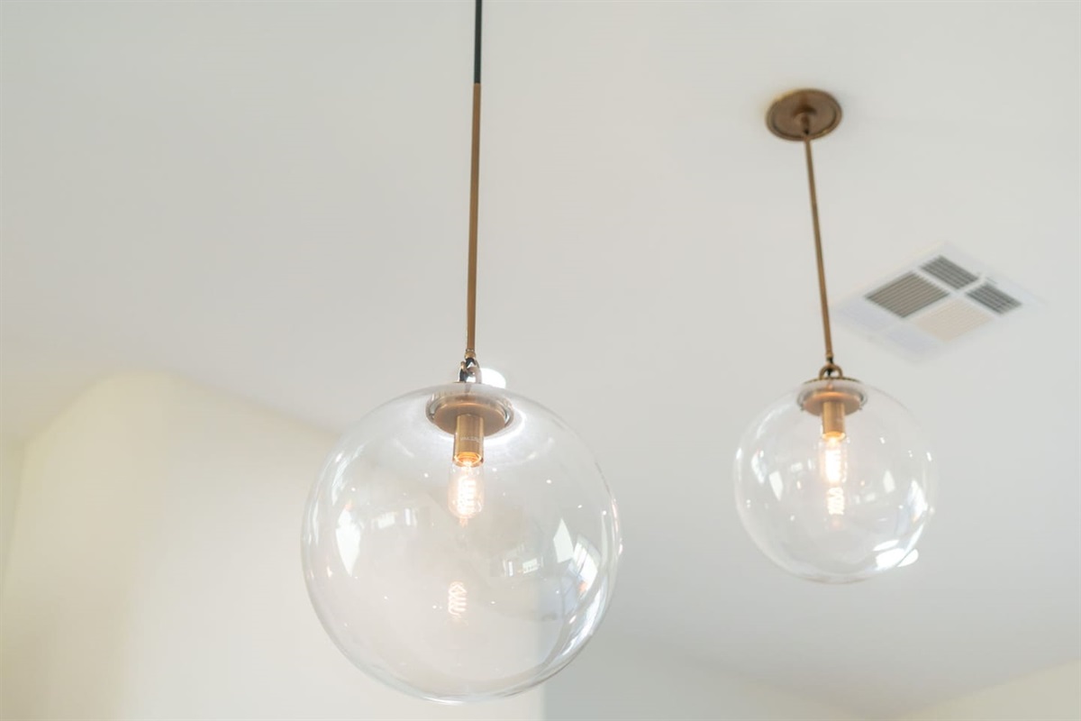 Elegant pendant lighting adds a modern touch and warm glow to the kitchen, creating a stylish and inviting atmosphere.