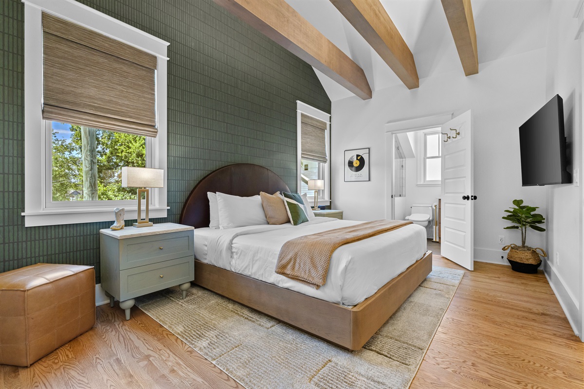 Bedroom retreat with vaulted ceilings, exposed beams, and a king bed.