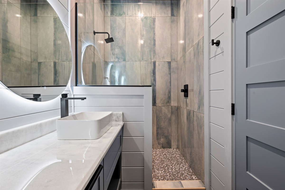 A spacious walk-in shower with beautiful tile details gives this bathroom a fresh and modern feel.