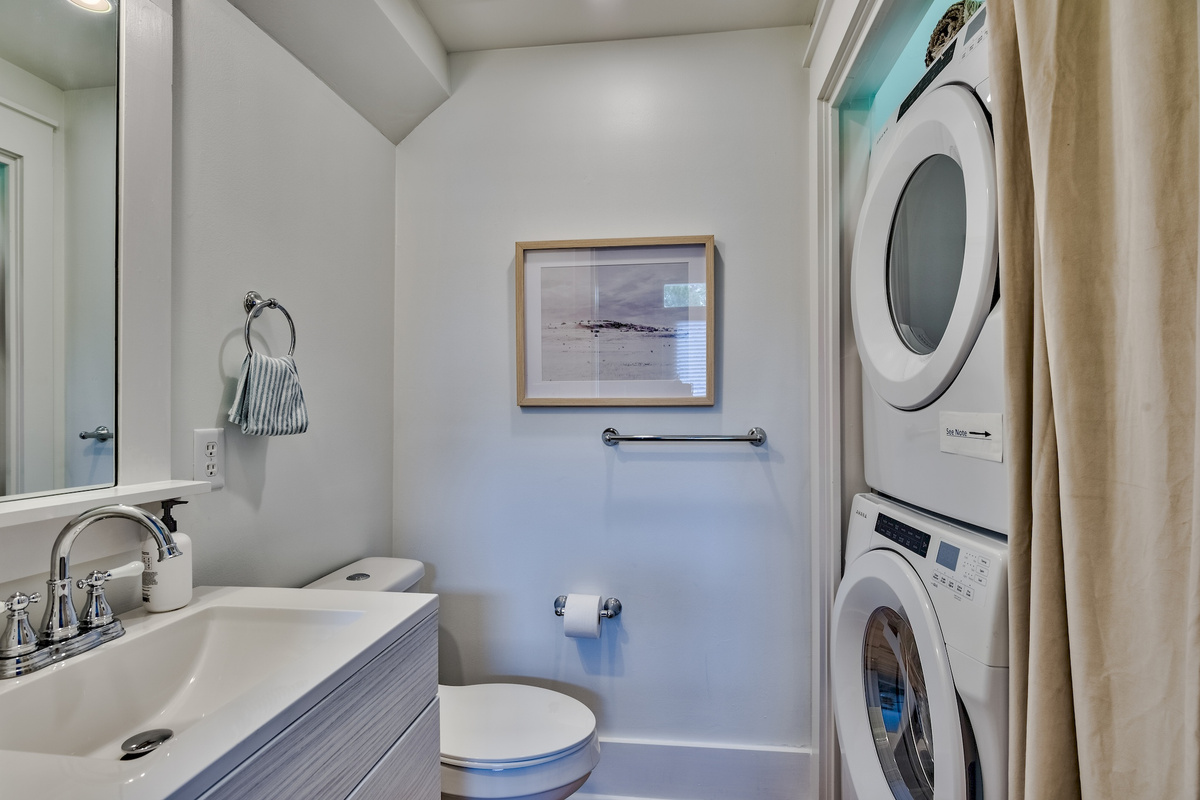Half bathroom with stacked washer and dryer