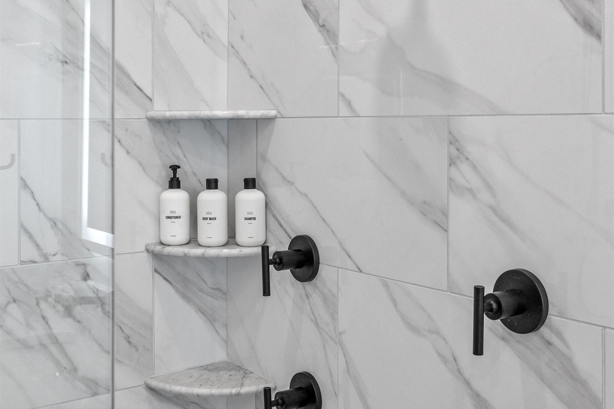 First floor master bathroom with dual vanities, heated floors, and walk in shower