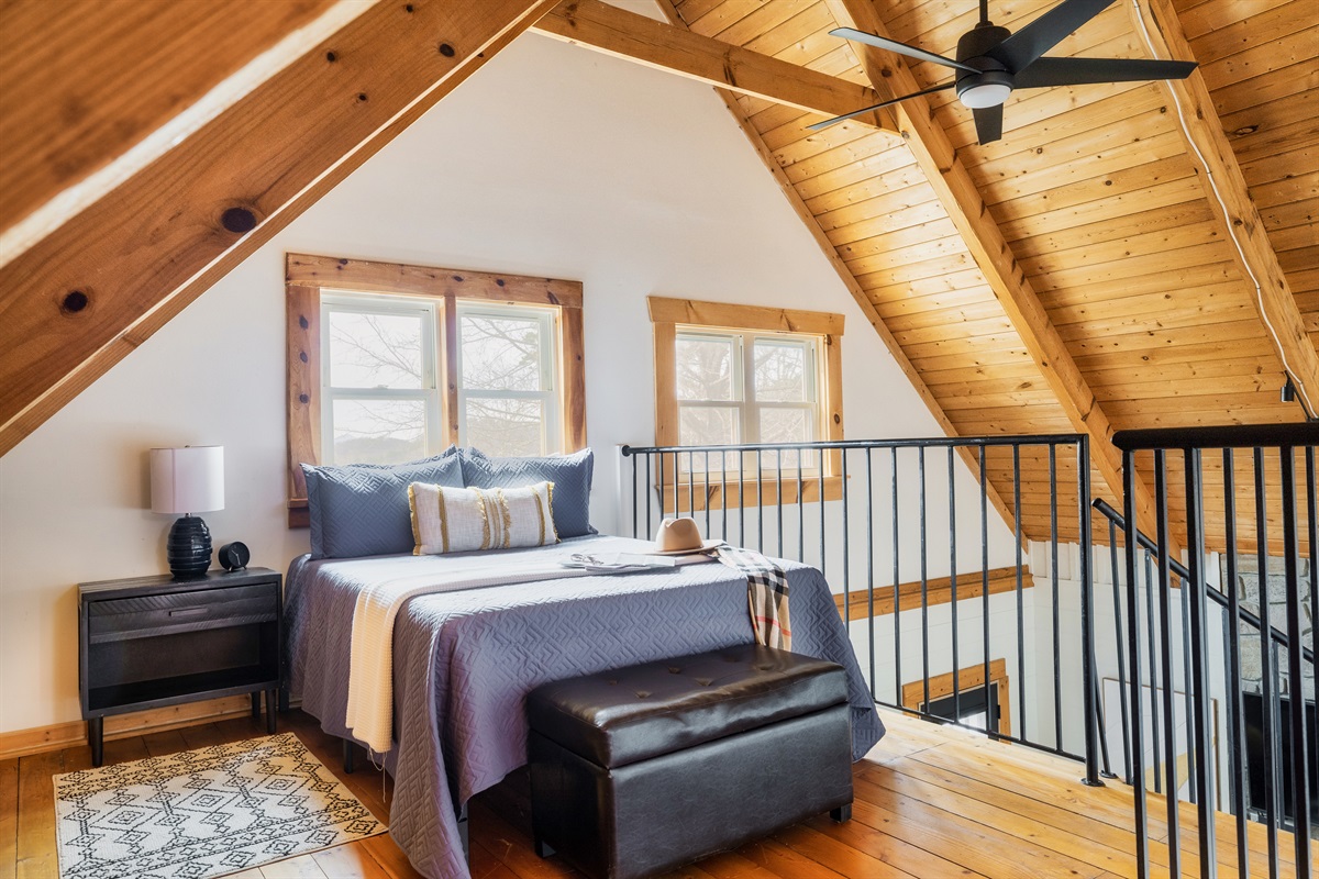 Escape to our charming loft bedroom on the upper level, featuring a cozy double bed perfect for a peaceful night's rest.