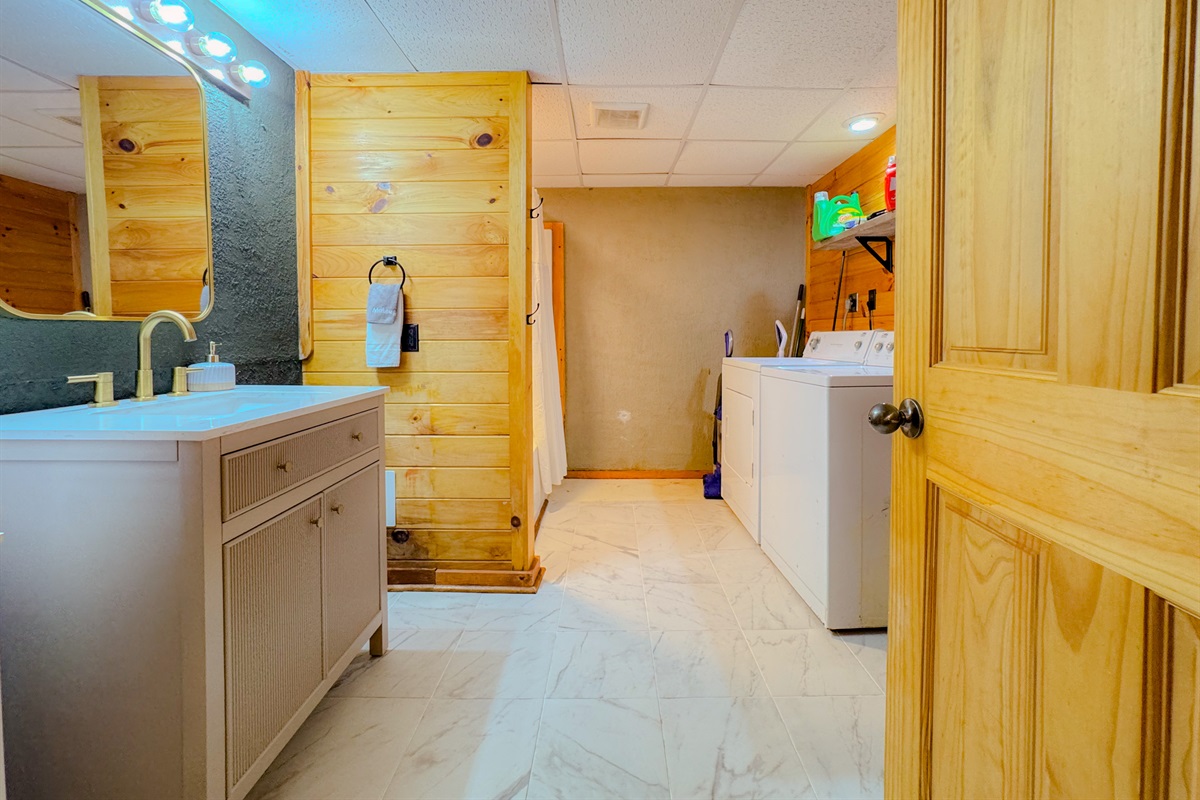 lower level bathroom features a washer and drew for guest use