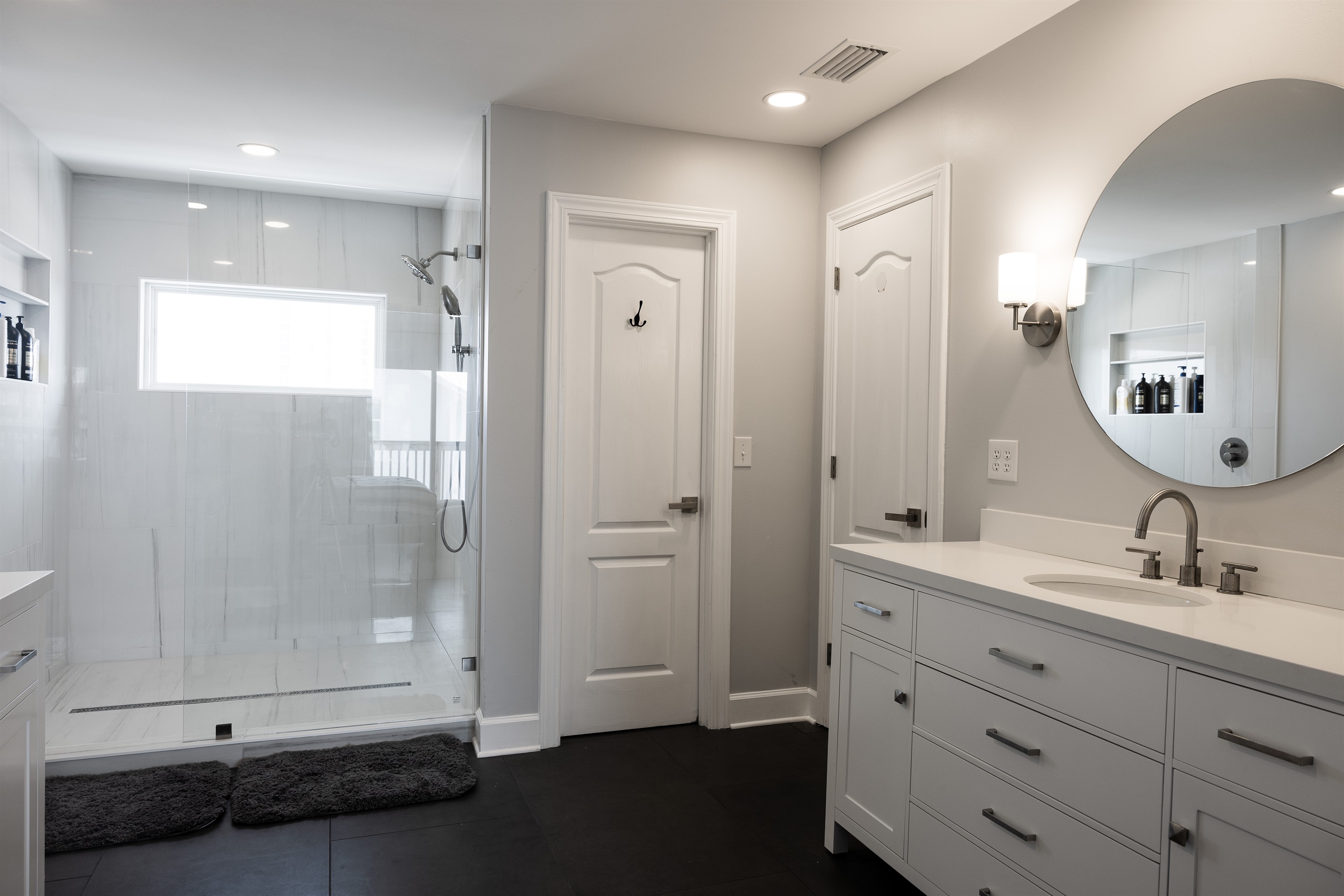 Primary Suite Bath with walk-in closet, double vanities and luxury shower with Lagoon views