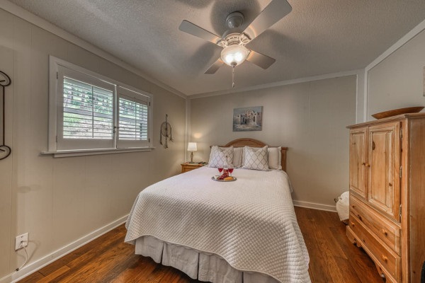 Relax in the spacious bedroom with a luxurious queen-sized bed and a charming cabinet, offering comfort and style for a restful stay.
