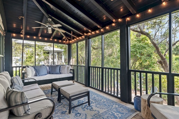 Screened Porch
A guest favorite, the screened-in porch features a cozy bed swing, sofa, rocker, and footstools. Two ceiling fans and string lights create the perfect setting for morning coffee, family time, or evening wine with peaceful wooded views.