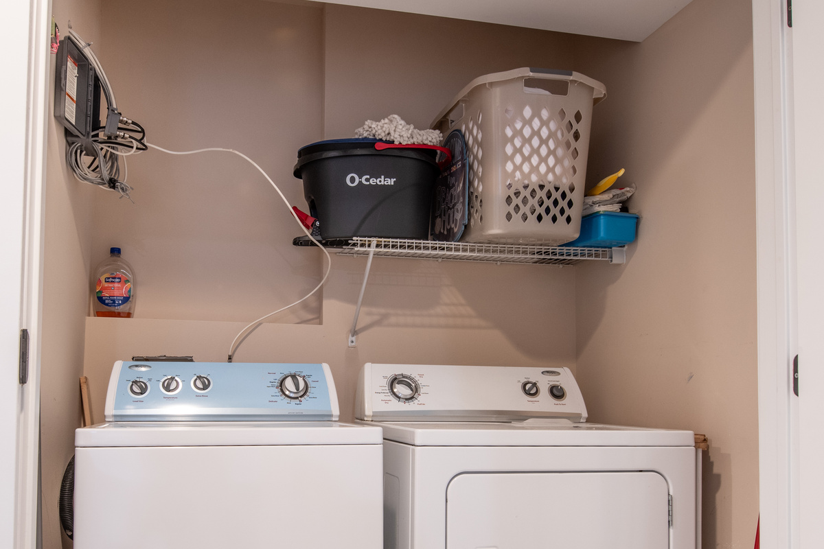 Laundry Closet Equipped with Washer, Dryer, and Storage Shelving