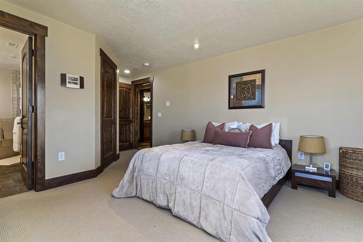 A spacious and thoughtfully designed primary bedroom, blending comfort and sophistication with warm tones and inviting textures.