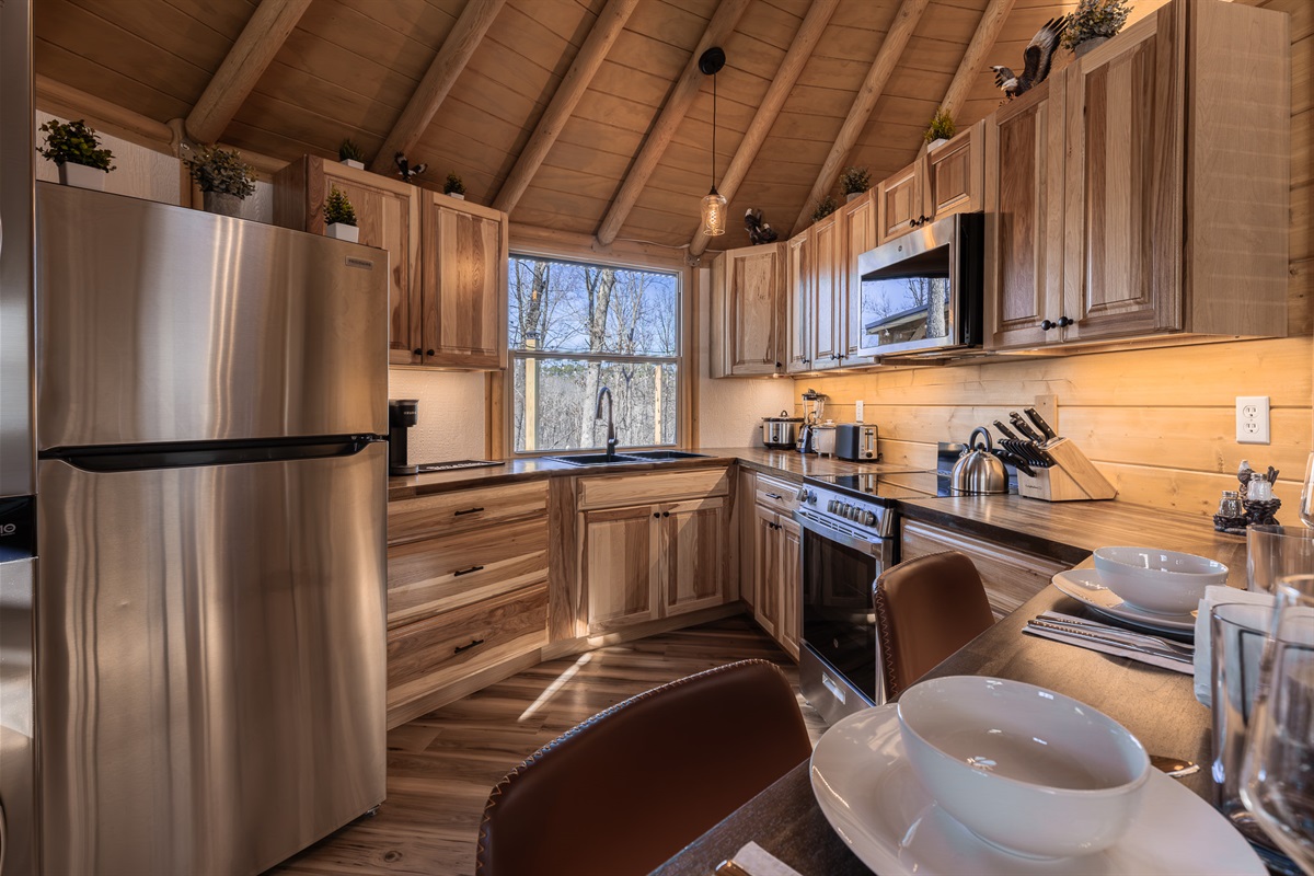 Fully equipped kitchen with full-size stainless appliances, custom wood cabinetry, and everything needed for relaxed meals or romantic dinners in the dome.