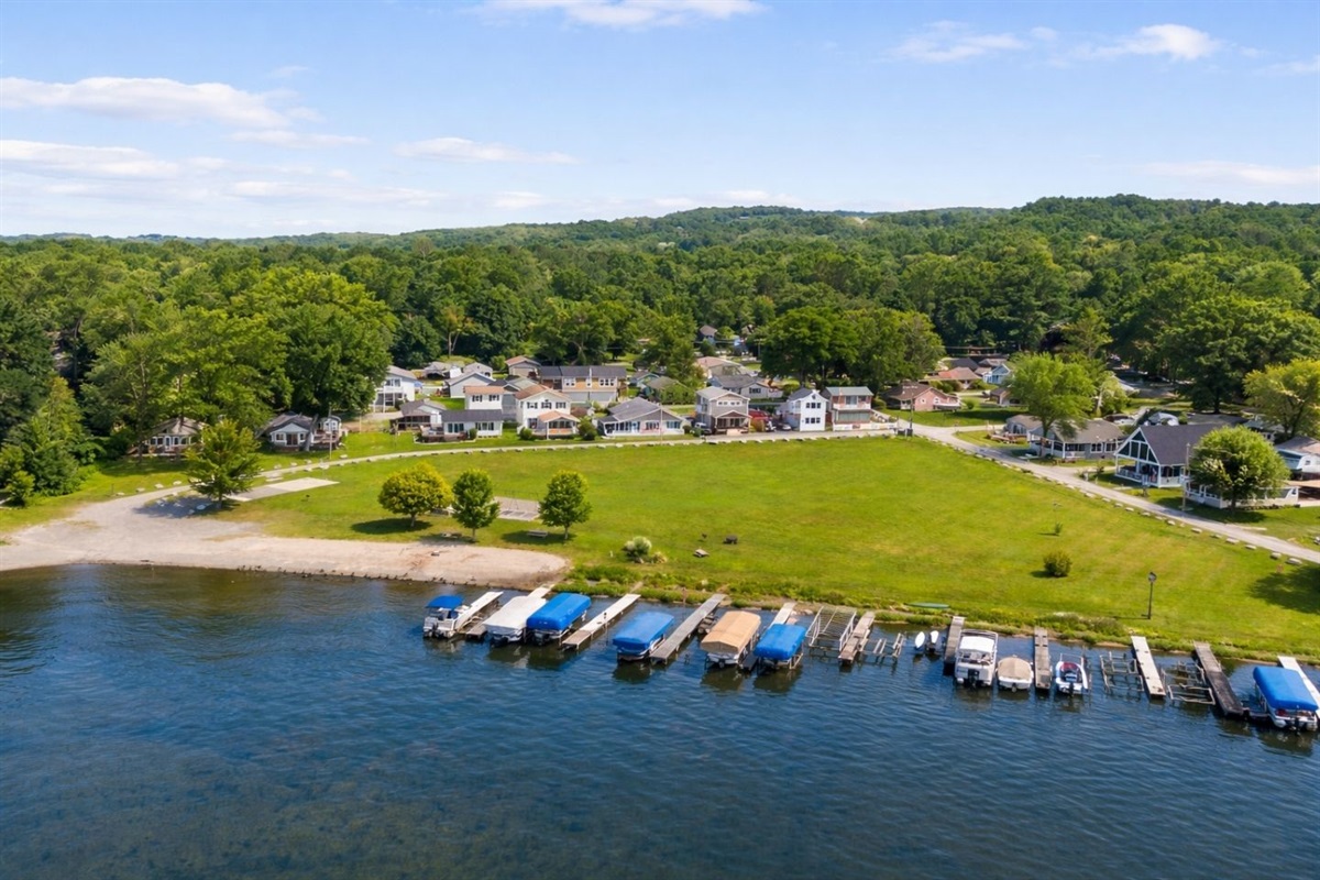 Picturesque lakefront area with docks and a serene park, perfect for boating and outdoor activities. ️