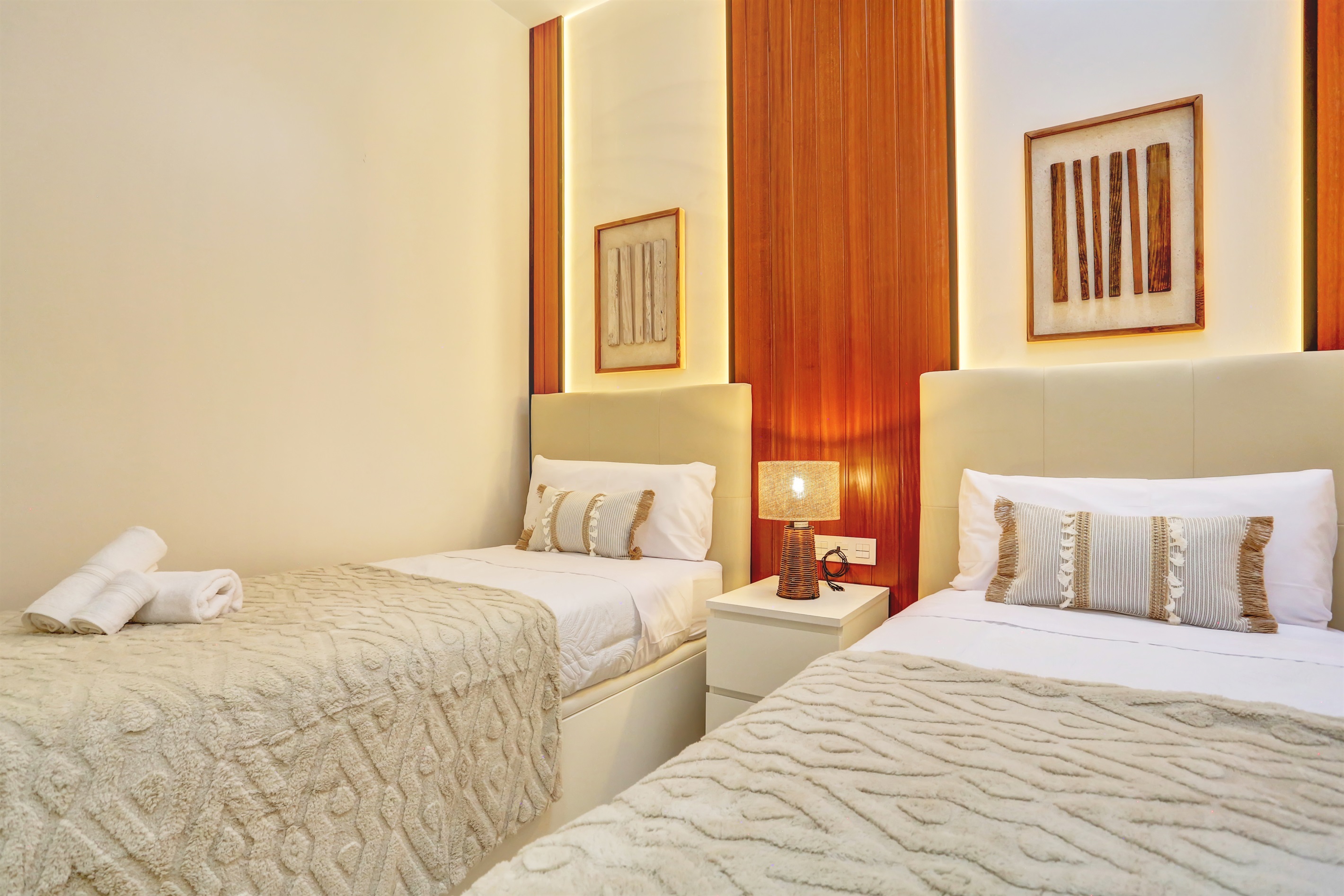 Cosy second bedroom with two single beds, elegant décor, and a warm, relaxing atmosphere.