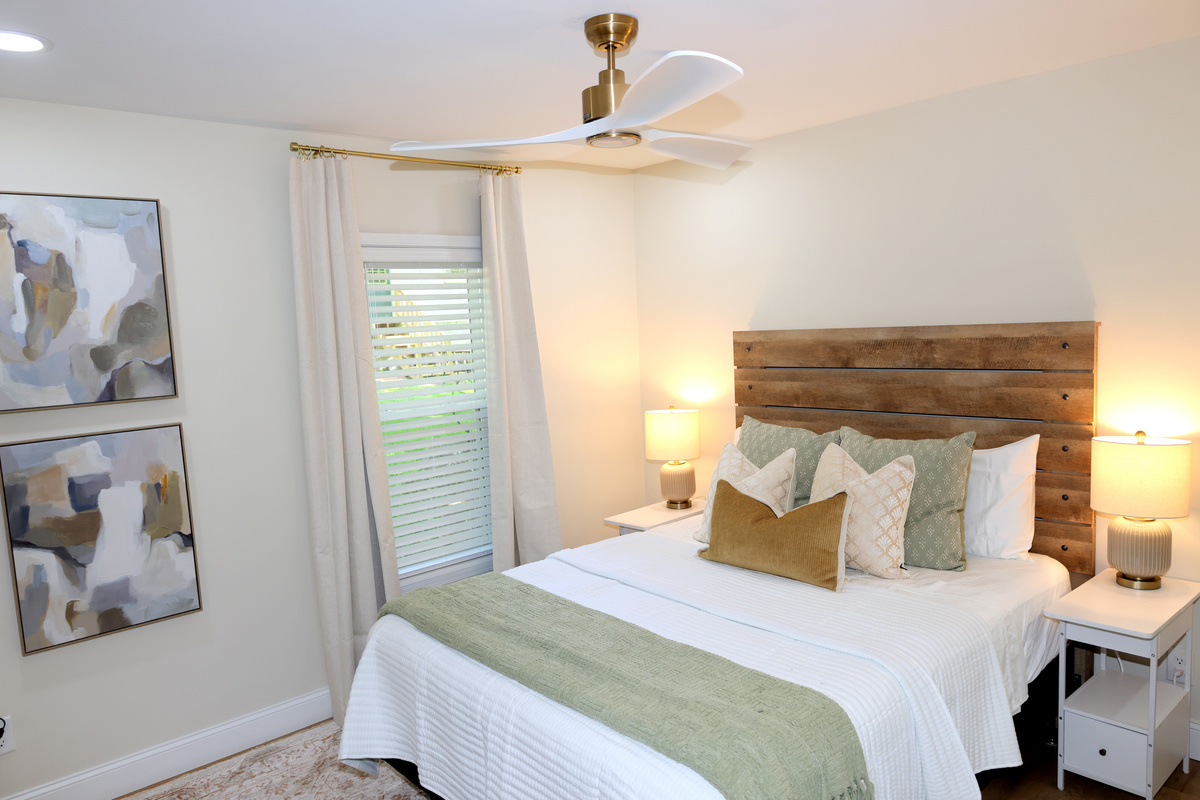 Cozy bedroom with warm wood headboard, soft bedding, and relaxing lake-house décor