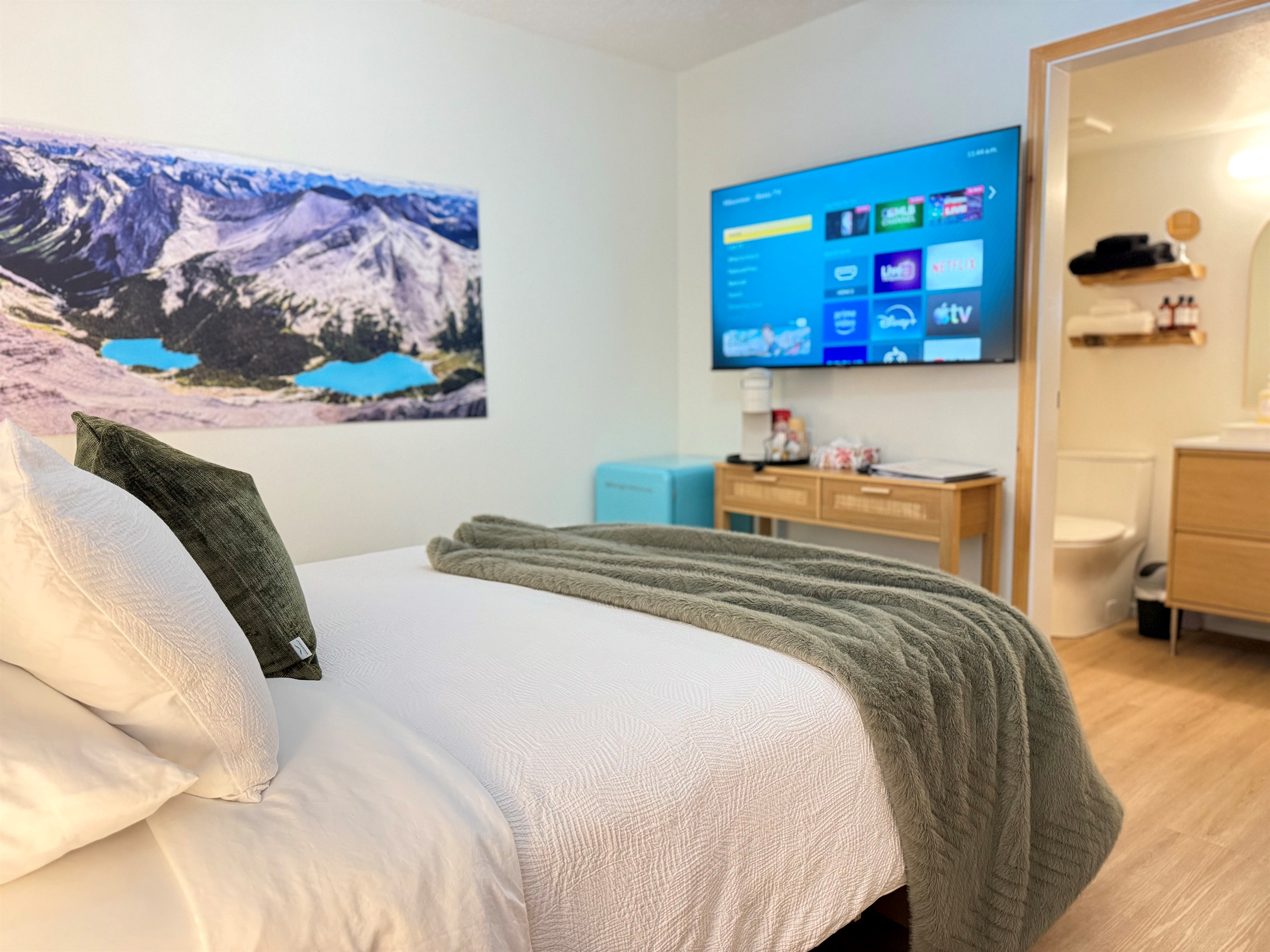 Relaxation Zone: The comfortable queen bed is complemented by mountain imagery of local lakes and entertainment options for the perfect mountain retreat.