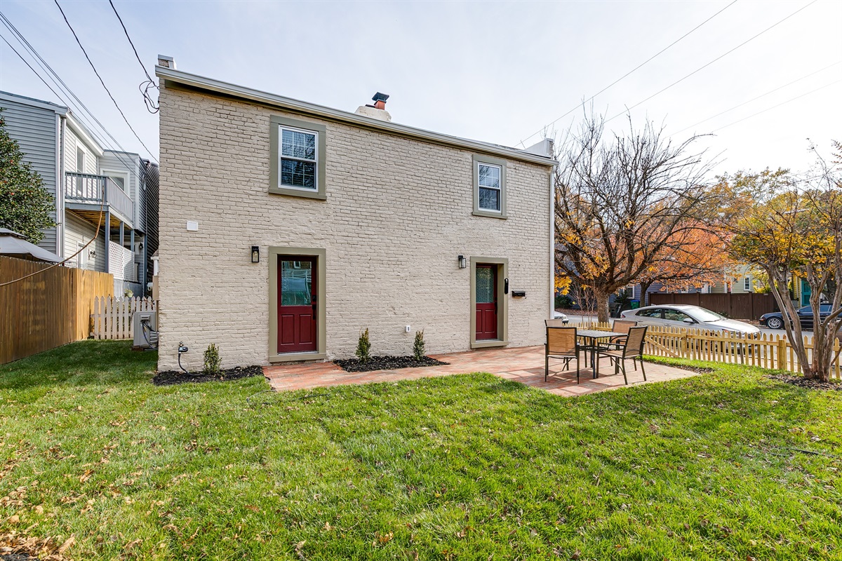 Charming Exterior: Enjoy outdoor dining in a vibrant, spacious yard with inviting seating!