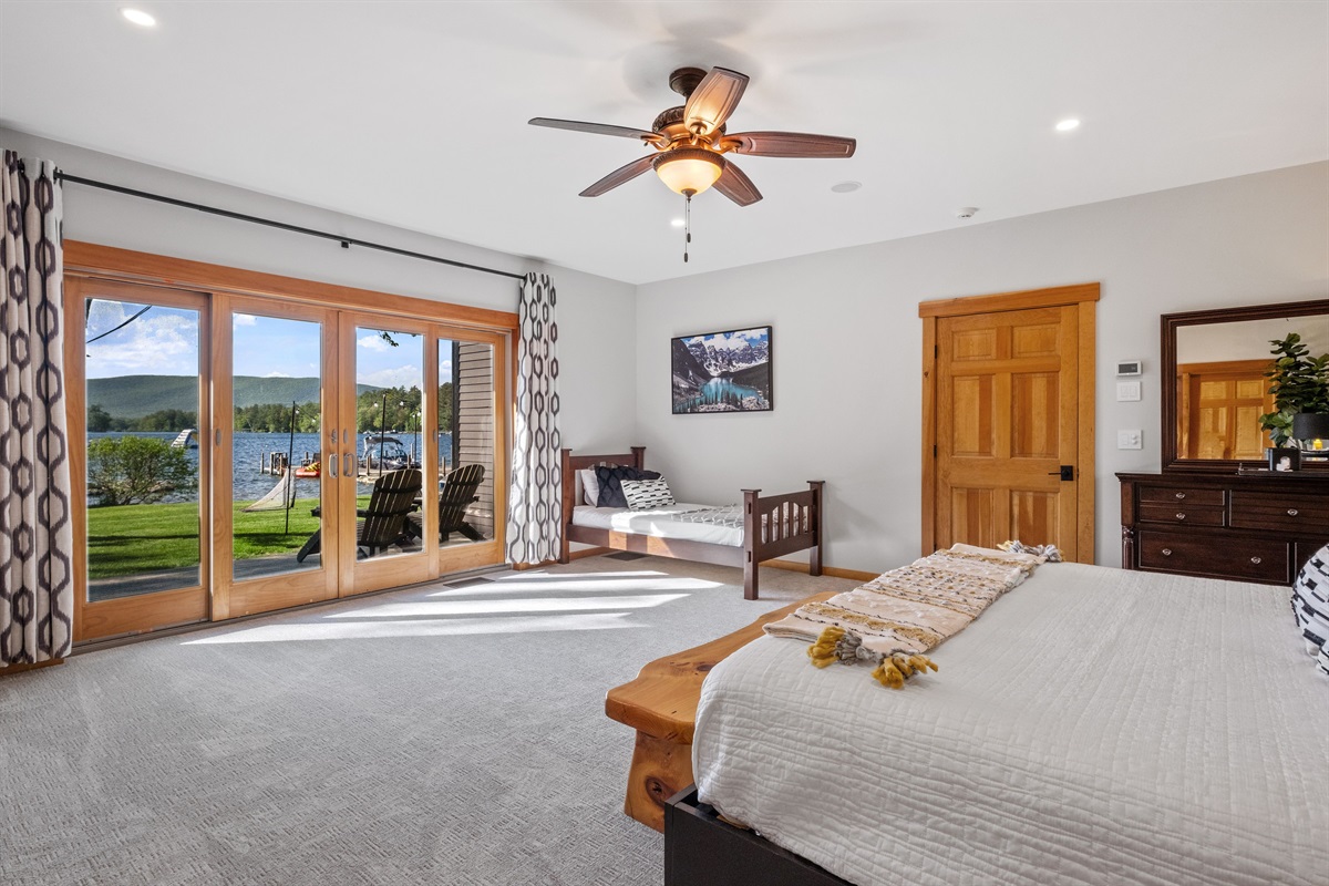 First floor master bedroom ensuite with king and twin beds overlooking Lake Winnipesaukee with hot tub on outside deck.
