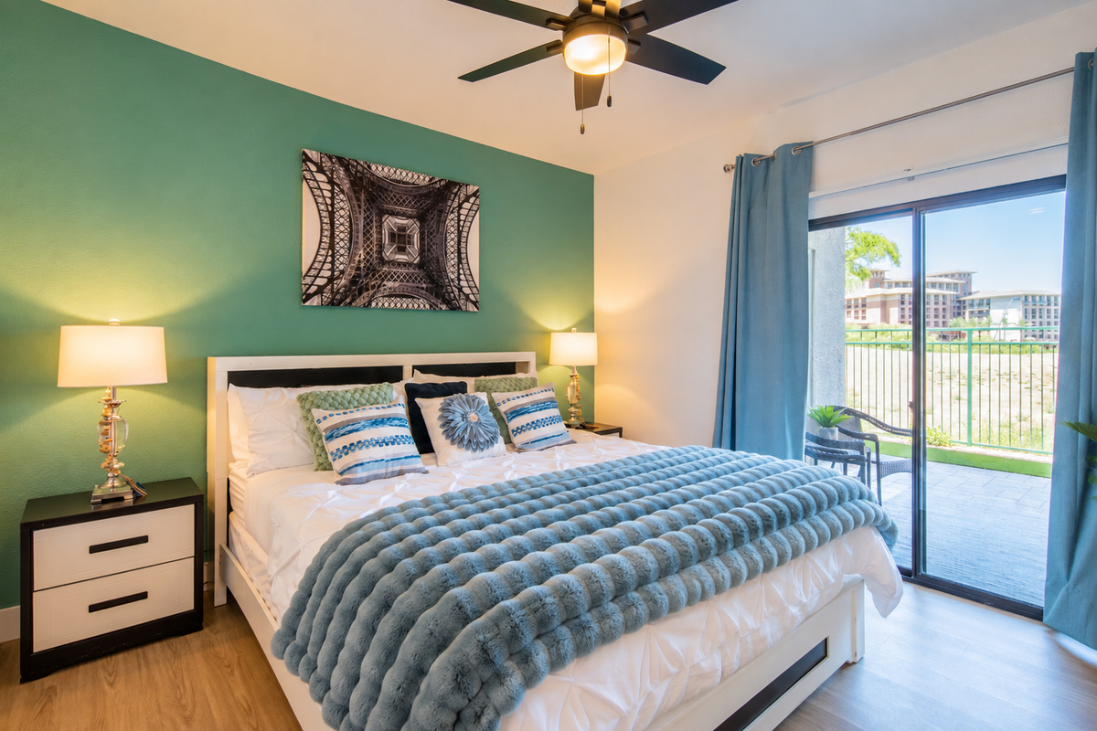 - Wake up to patio views and natural light in this spacious bedroom   - Soft blue tones and plush bedding create a serene, restful ambiance   - Watch TV from bed or step outside for a breath of fresh morning air