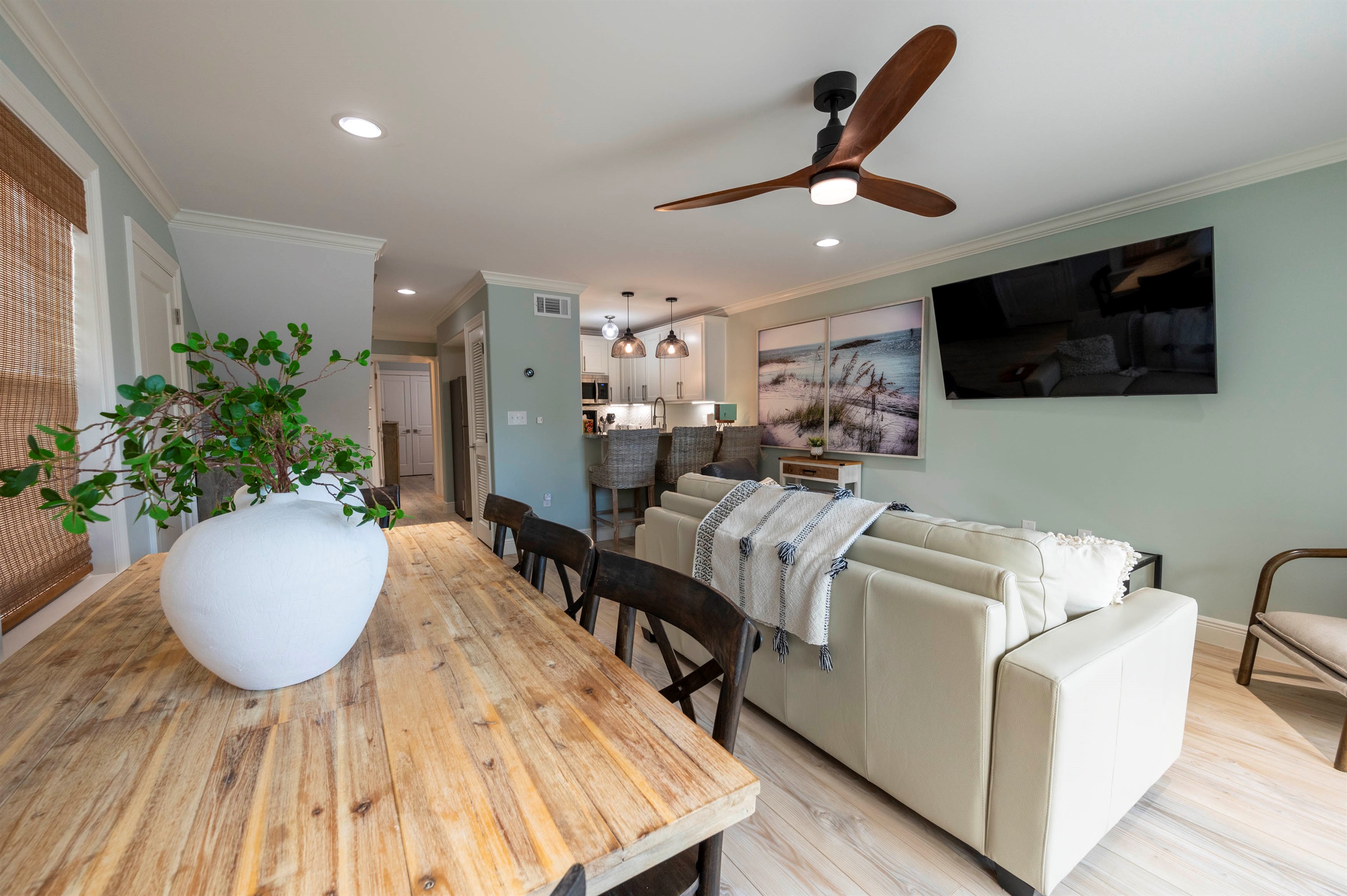 Cozy beach-themed living room with stylish decor, a wooden table, and vibrant wall art.
