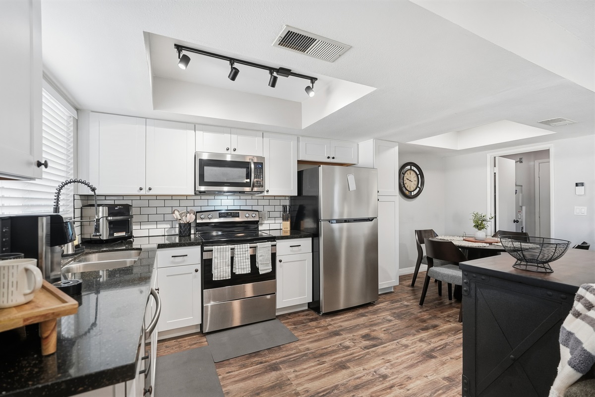 Bright, fully equipped kitchen with stainless appliances and inviting dining space.