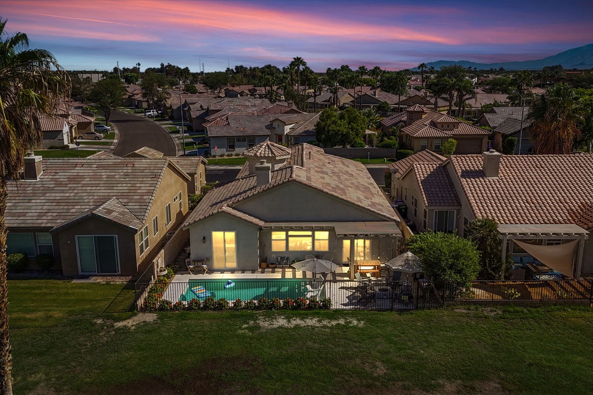 Experience stunning desert sunsets and mountain silhouettes as this home glows warmly at dusk—pure vacation serenity.