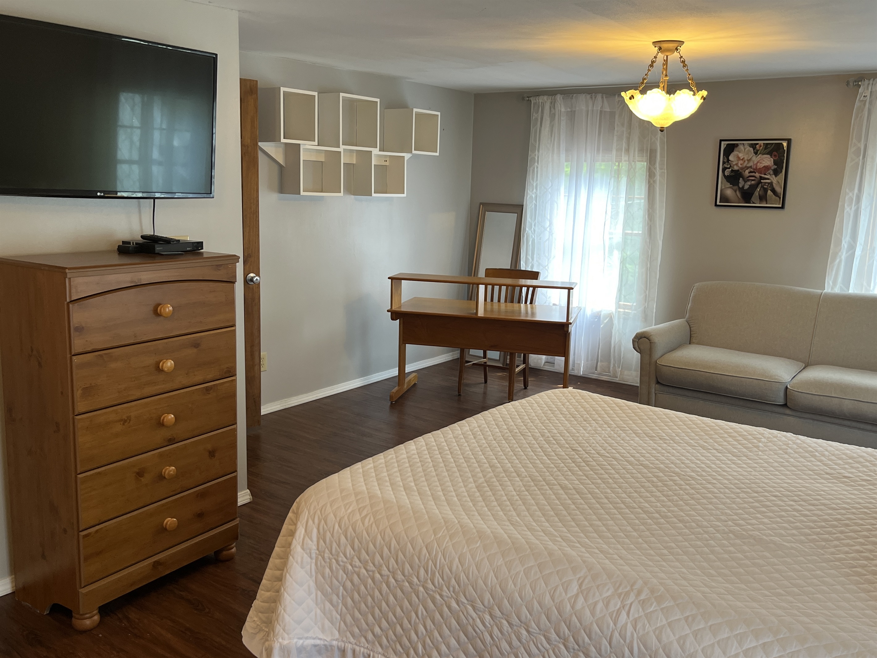 Primary bedroom with SmartTV and desk