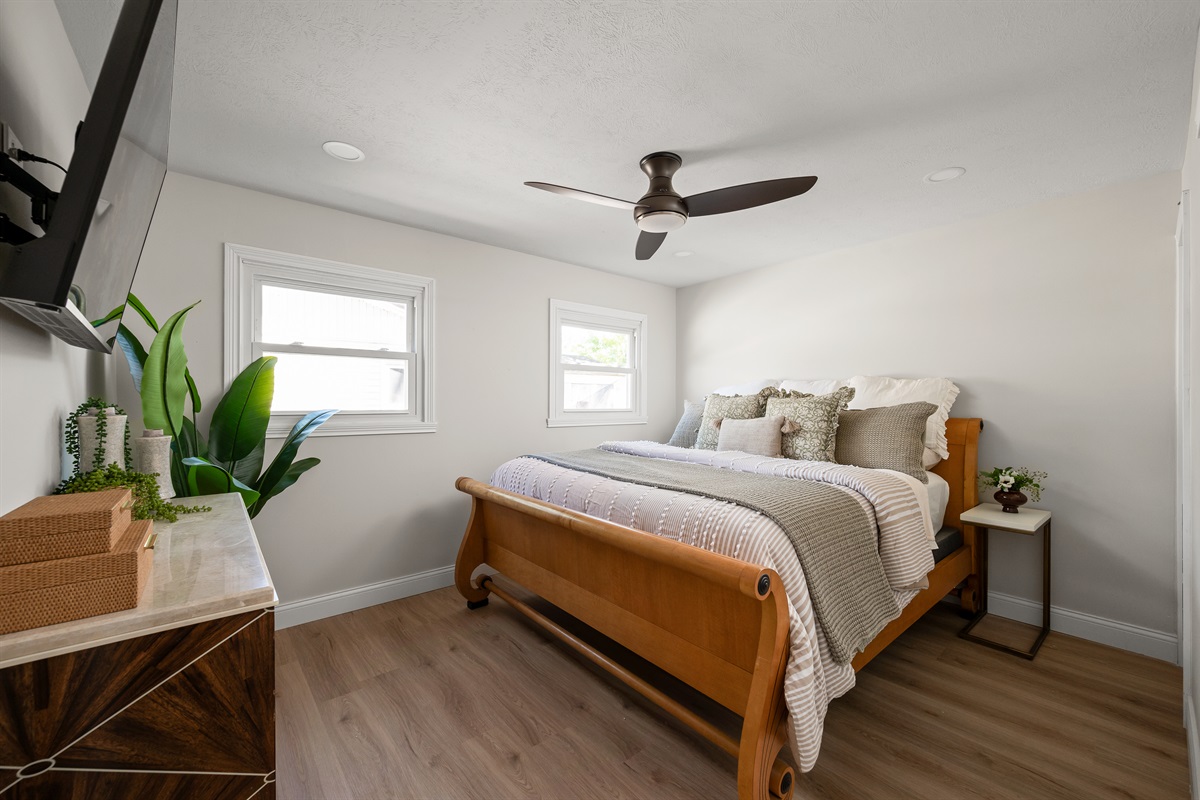 Relax in the spacious primary bedroom featuring a comfortable king size bed designed for a restful night’s sleep after a day exploring Indy.